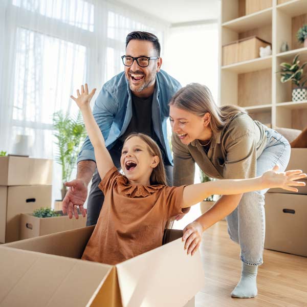 family having fun with a child sitting in a cardboard box